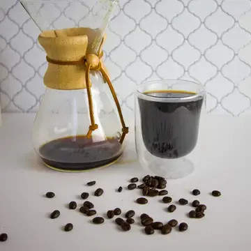 Café filtre dans une carafe en verre, à côté d’une tasse pleine