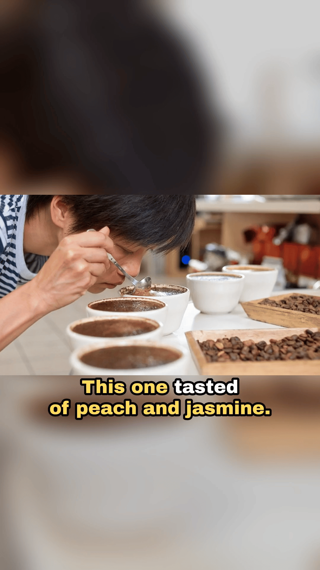 Un fotograma del vídeo vertical terminado: una cata de café, con el subtítulo «This one tasted of peach and jasmine.»